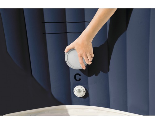 Detailní záběr ruky upevňující uzávěr na nafukovací vířivce