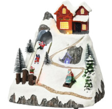 Dekorativní zimní krajina s domem, sáňkařskou dráhou a zasněženými stromy