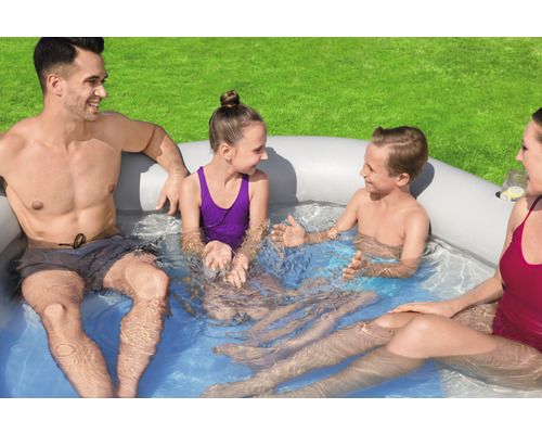 Rodina relaxuje v nafukovací vířivce na zahradě.