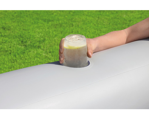 Ruka drží nápoj s kostkami ledu v držáku nápojů na nafukovacím povrchu