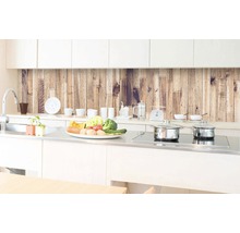 Světlá kuchyně s dřevěným obkladem stěn, dřezem, varnou deskou a hrnci.