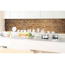 Kuchyňská scéna s nástěnným panelem se vzorem cihel nad pracovní deskou.