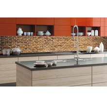 Moderní kuchyně s nástěnným panelem s cihlovým vzorem, dřezem a kuchyňským náčiním.