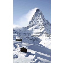 Matterhorn v zimě s dřevěnými chatami ve sněhu.