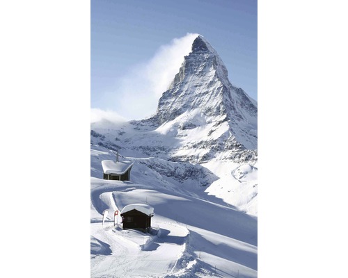 Matterhorn v zimě s dřevěnými chatami ve sněhu.