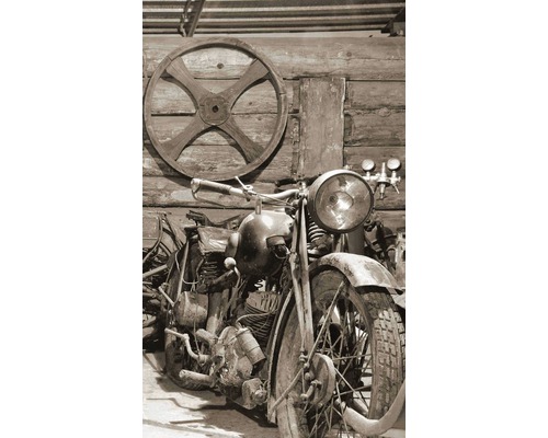 Starý motocykl před dřevěnou stěnou s dřevěným kolem.