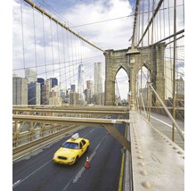 Pohled z Brooklynského mostu na panorama New Yorku se žlutým taxíkem na silnici