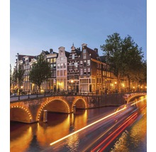 Amsterdamské kanály s osvětlenými mosty a historickými domy v noci