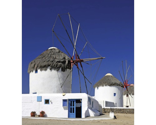 Řecké větrné mlýny se slaměnými střechami a bílými stěnami pod modrou oblohou