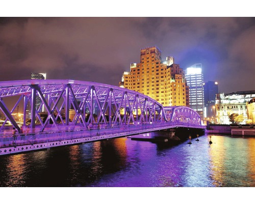 Osvětlený most přes řeku ve městě v noci