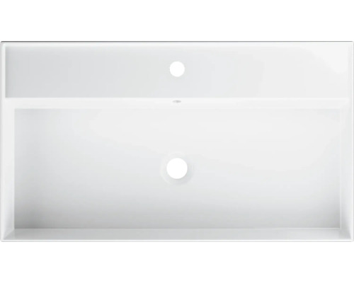 Pohled shora na bílé umyvadlo s otvorem pro baterii a přepadem