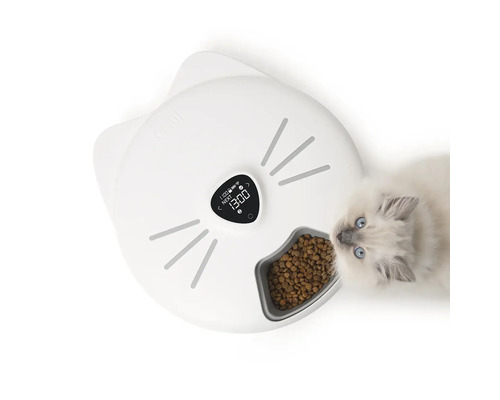 Bílý automatický podavač krmiva ve tvaru kočky s kočkou, která jí