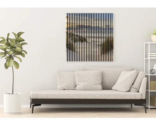 Obývací pokoj s denní postelí a nástěnným obrazem s motivem pláže a svislými pruhy.