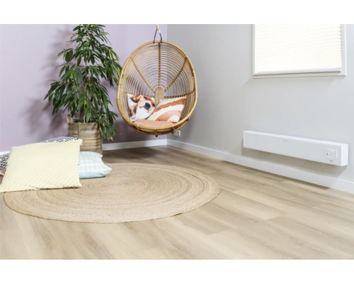 Obývací pokoj s ratanovým křeslem, kulatým jutovým kobercem, pokojovou rostlinou a nástěnným topením