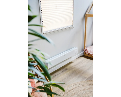 Scéna s bílým nástěnným konvektorovým ohřívačem v místnosti s dřevěnou postelí ve tvaru domečku