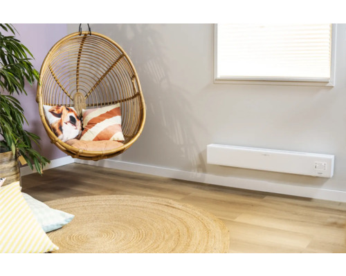 Obývací pokoj s ratanovým křeslem, polštáři, kobercem a radiátorem