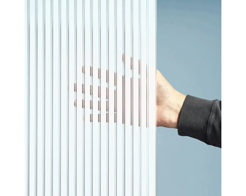 Detailní záběr rýhované skleněné desky s rukou za ní