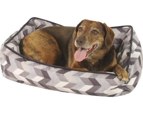 Pes leží v pelíšku s geometrickým vzorem