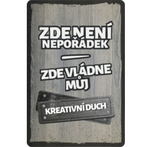 Dekorativní štítek s nápisem ''Tady není nepořádek, tady vládne můj tvůrčí duch''.