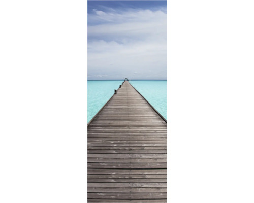 Dlouhé dřevěné molo nad tyrkysovou vodou pod zataženou oblohou