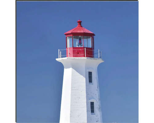 Maják s červenou střechou na modré obloze