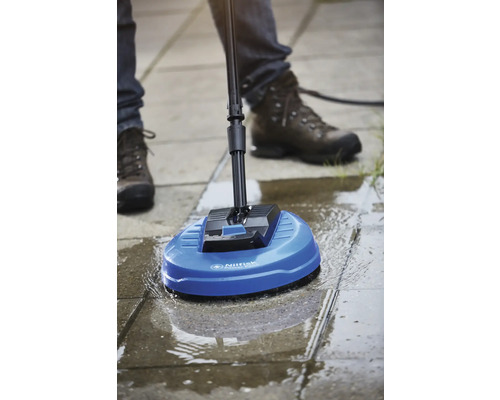 Osoba používá čistič povrchů Nilfisk k čištění dlážděné plochy.