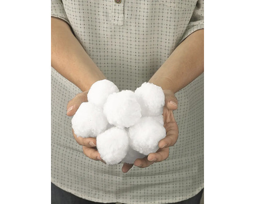 Osoba drží v rukou umělé sněhové koule.