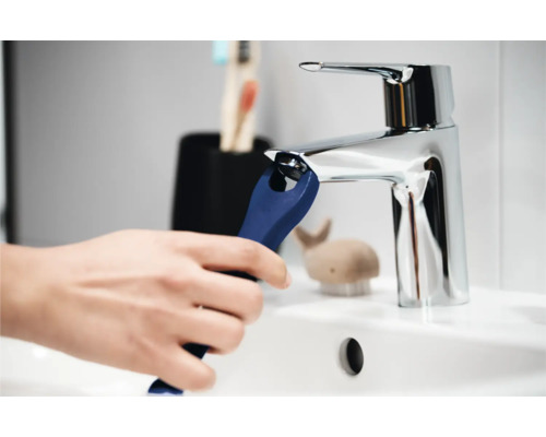 Čištění armatur s nářadím v umyvadle v koupelně