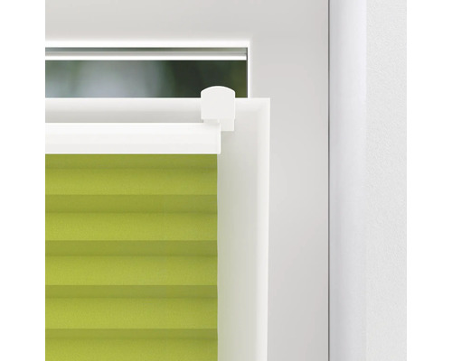 Detailní záběr zelené plisované žaluzie na okně
