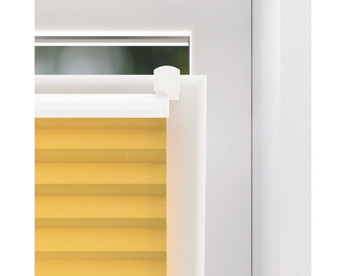 Detailní záběr žluté plisované žaluzie na okně