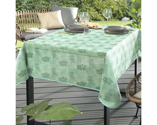 Stůl se světle zeleným ubrusem s listovým vzorem pro venkovní použití