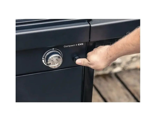 Osoba stiskne zapalovací tlačítko plynového grilu