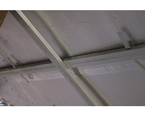 Pohled na izolaci střechy s reflexní fólií a kovovým rámem