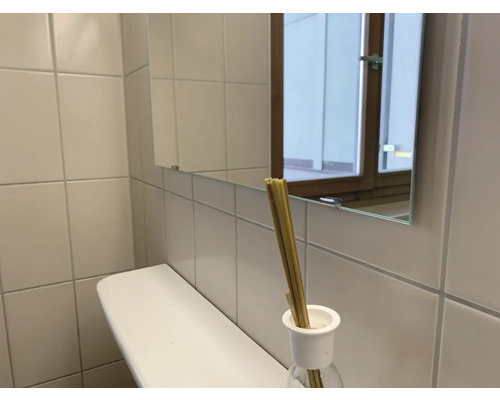 Koupelna s umyvadlem, zrcadlem a vonnými tyčinkami