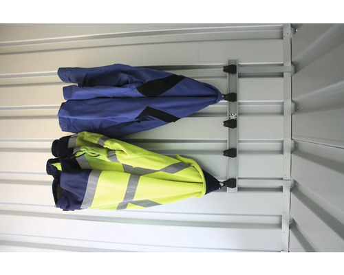 Dvě pracovní bundy visí na nástěnném lištovém systému.