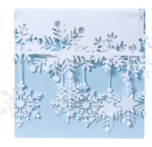Dekorativní papír s vyřezávanými sněhovými vločkami jako zimní dekorace