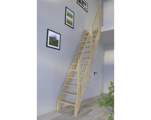 Pohled do místnosti s dřevěným schodištěm připevněným ke stěně s zarámovanými obrázky