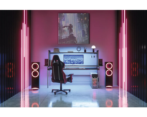 Herní místnost se stolem, počítačem, židlí, reproduktory a LED osvětlením vytváří moderní atmosféru.