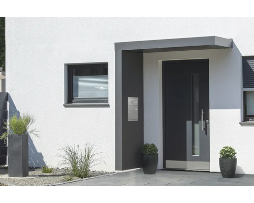 Moderní fasáda domu s vchodovými dveřmi, oknem a květináči