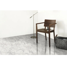 Světlá místnost s podlahou s mramorovým vzhledem, židlí, stojací lampou a košem