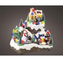 Dekorativní vánoční scéna s domy, stromy, sněhulákem a figurkami