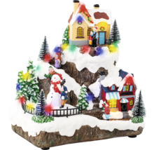 Dekorativní zimní krajina s domy, stromy a figurkami