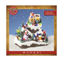 Osvětlená vánoční krajina s domy a figurkami