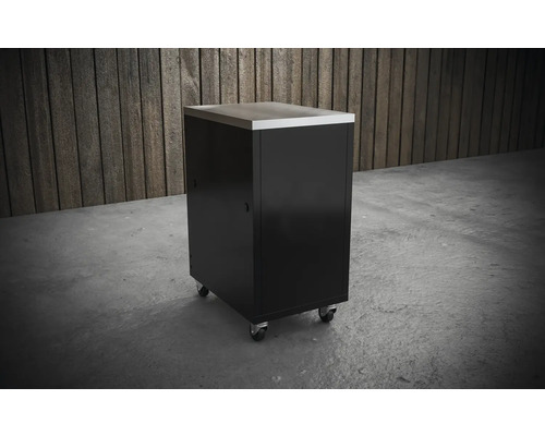 Pojízdná dílenská skříňka s nerezovou pracovní deskou před dřevěnou stěnou