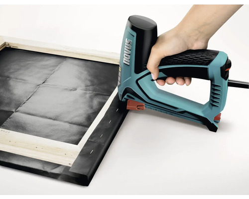 Osoba používá elektrickou sešívačku k napínání plátna na dřevěný rám. Logo Novus.