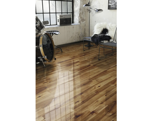 Světlá místnost s dřevěnou podlahou, bicí soupravou a židlí