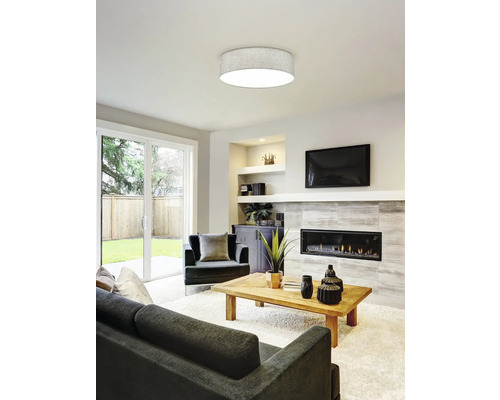 Obývací pokoj se stropním svítidlem, pohovkou, křeslem a krbem