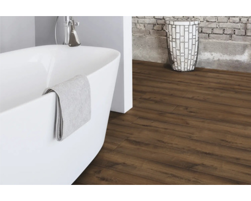 Koupelna s volně stojící vanou, košem na prádlo a laminátovou podlahou s dřevěným vzhledem.