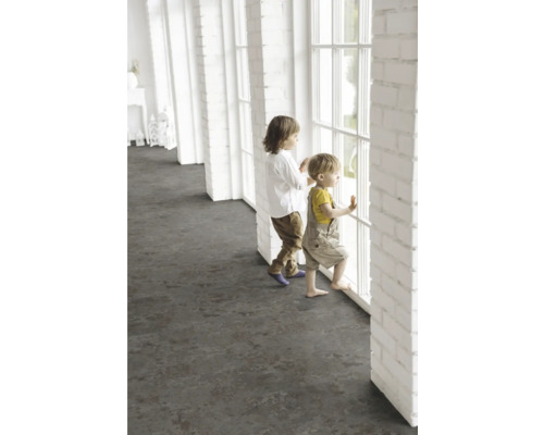 Děti stojí u okna ve světlé místnosti s tmavou podlahovou krytinou