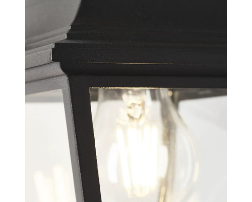 Detailní pohled na černé venkovní svítidlo se žárovkou.